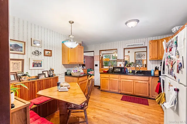 a very nice looking dining room with kitchen island furniture a rug and a chandelier