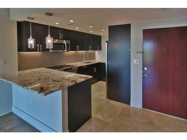 a kitchen with a sink a counter space and stainless steel appliances