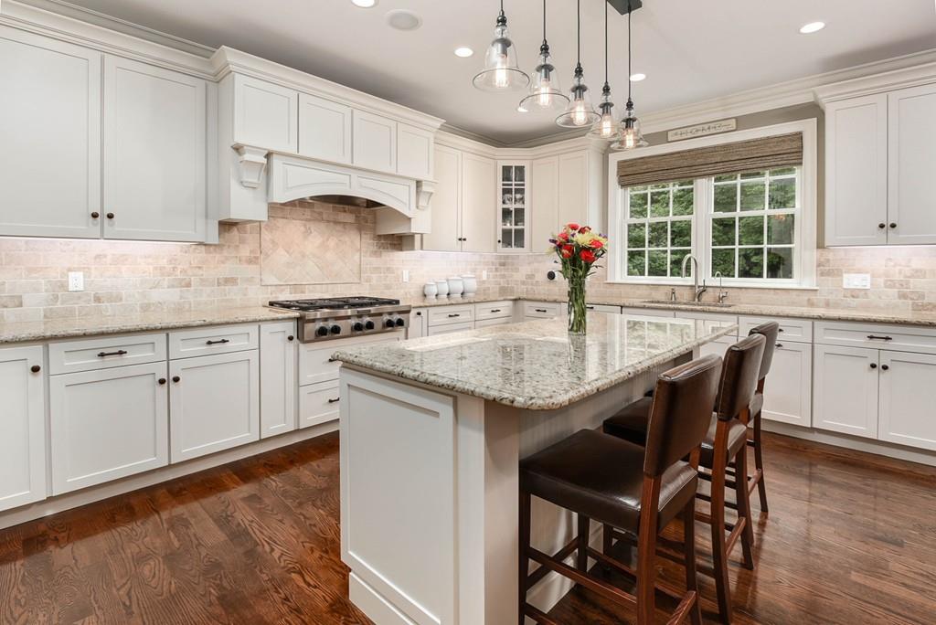 63 Ardmore Road Needham, MA 02494 - Photo 8 of 41 a kitchen with stainless steel appliances granite countertop a stove top oven a sink dishwasher and white cabinets with wooden floor