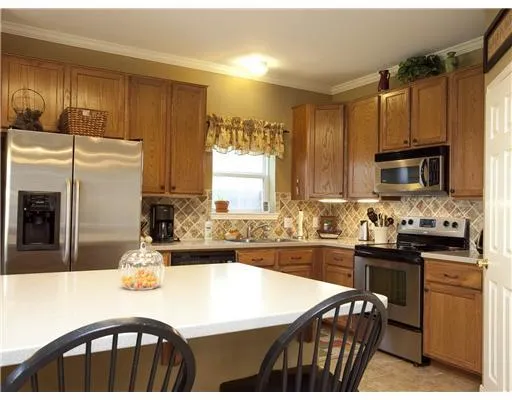 a kitchen with granite countertop a sink stove and refrigerator