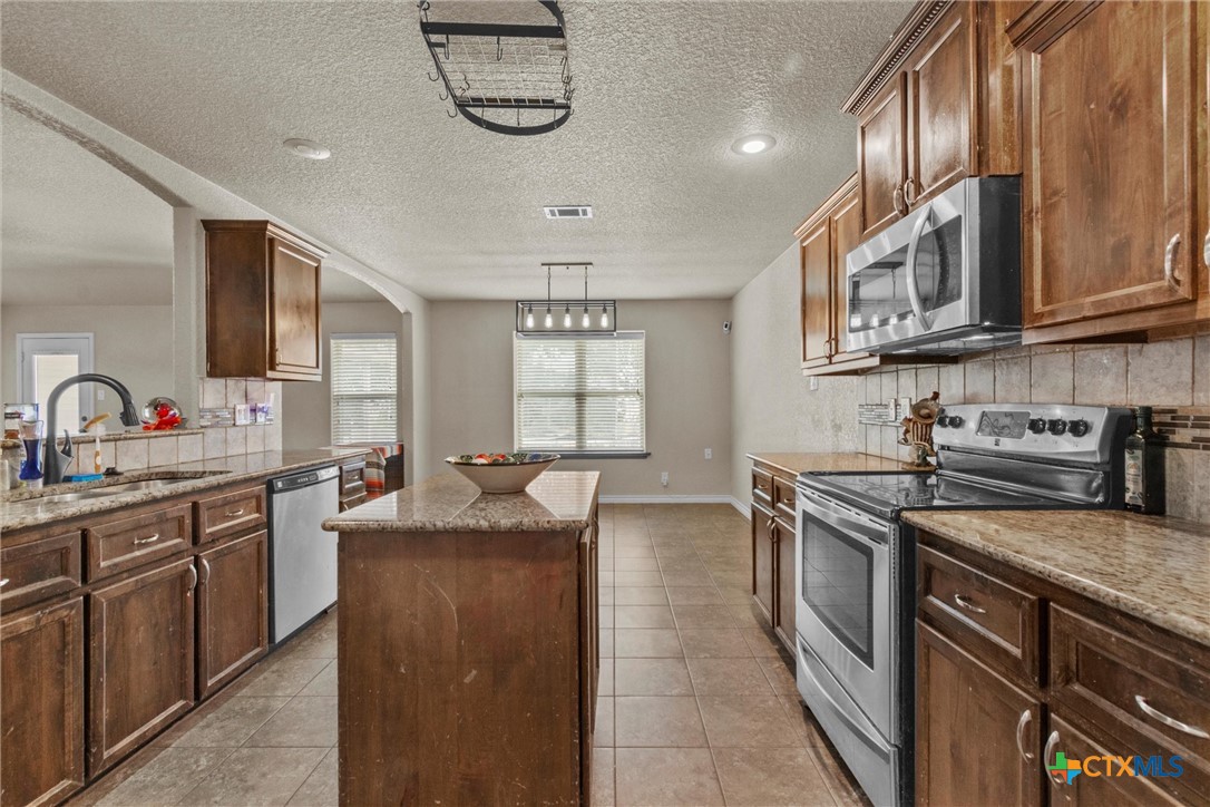 6405 Deorsam Loop Killeen, TX 76542 - Photo 14 of 36 a kitchen with stainless steel appliances granite countertop a sink stove and cabinets