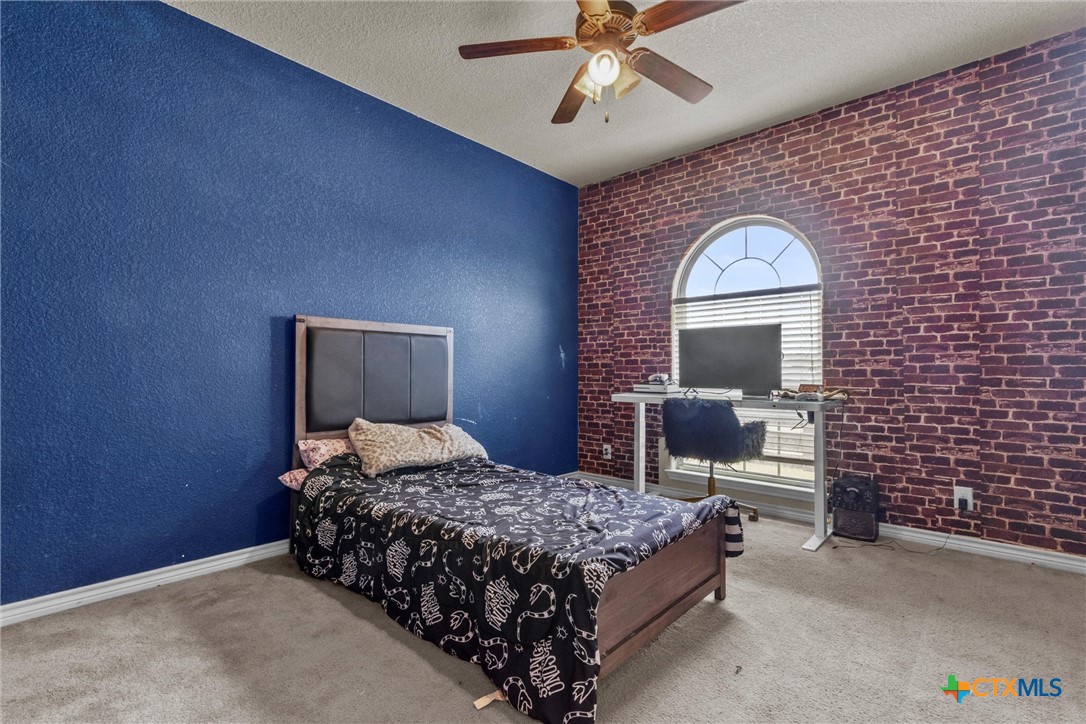 6405 Deorsam Loop Killeen, TX 76542 - Photo 22 of 36 a bedroom with a bed lamp and a fireplace