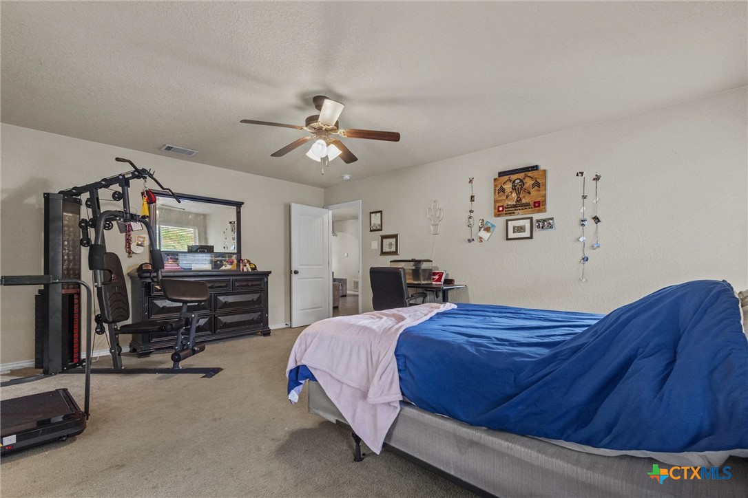 6405 Deorsam Loop Killeen, TX 76542 - Photo 24 of 36 a bedroom with a bed and a chandelier