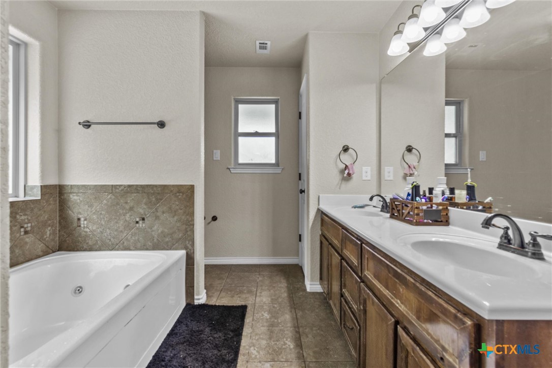 6405 Deorsam Loop Killeen, TX 76542 - Photo 27 of 36 a bathroom with a tub a sink and a mirror
