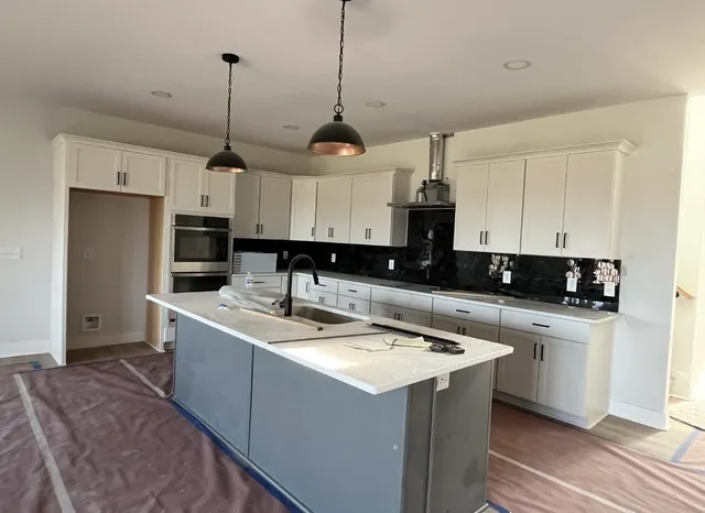 a kitchen with a sink stainless steel appliances and white cabinets