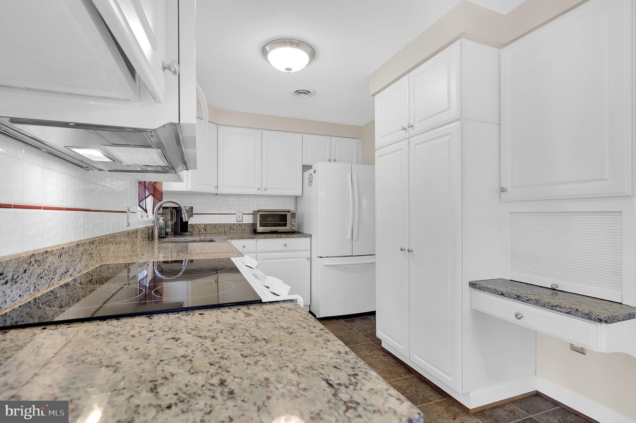5709 Adamstown Road Adamstown, MD 21710 - Photo 11 of 42 a kitchen with white cabinets and white appliances