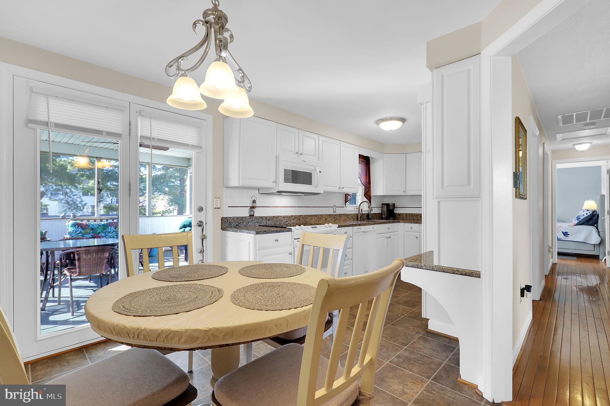 5709 Adamstown Road Adamstown, MD 21710 - Photo 7 of 42 a kitchen with kitchen island granite countertop a sink a center island a refrigerator and a wooden cabinets