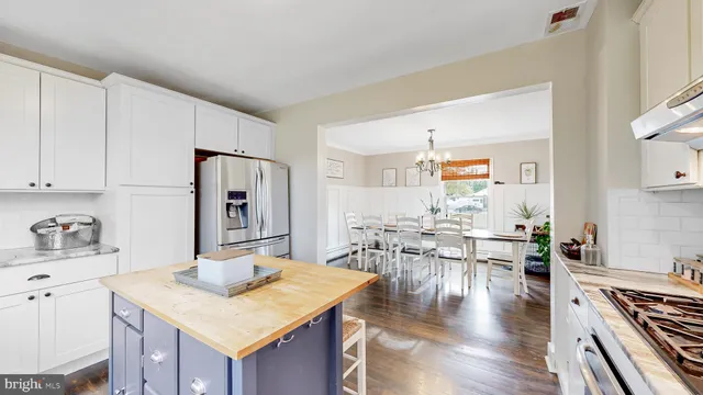 a kitchen with stainless steel appliances wooden floor dining table and chairs