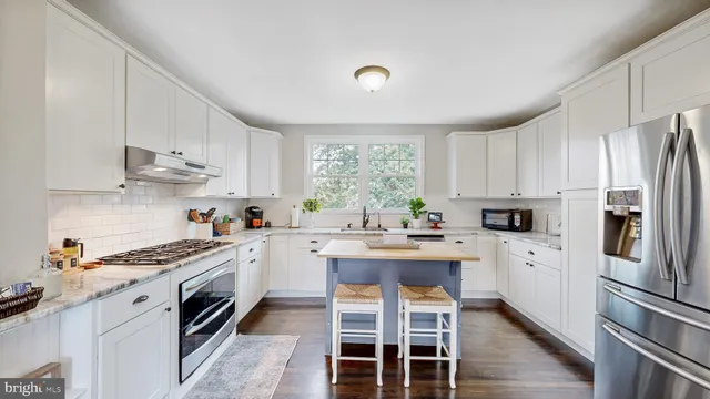 a kitchen with white cabinets and appliances