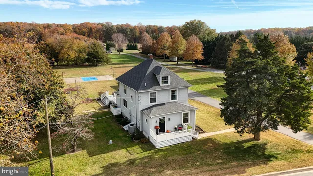 an aerial view of a house with a yard basket ball court and outdoor seating