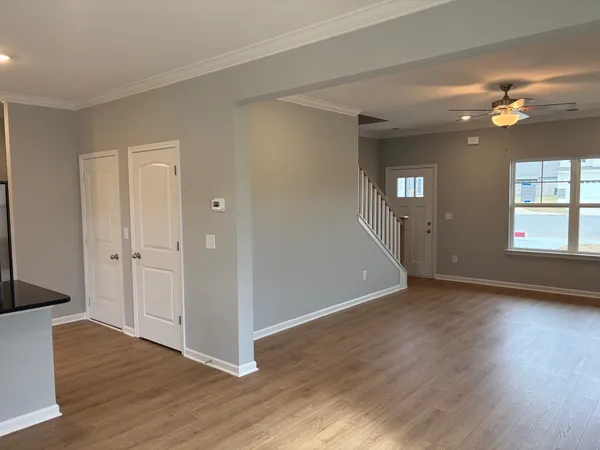 a view of an empty room with window and wooden floor