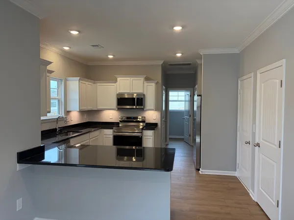 a kitchen with stainless steel appliances a sink a stove a microwave and cabinets