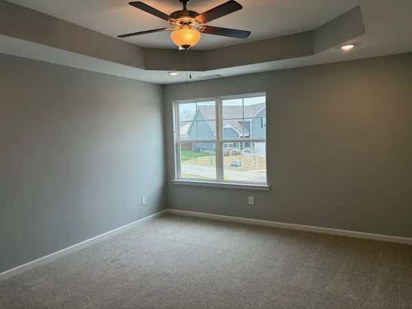 an empty room with a window and a fan