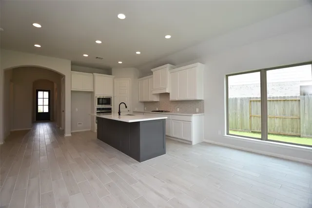 a large kitchen with stainless steel appliances lots of counter space and a sink