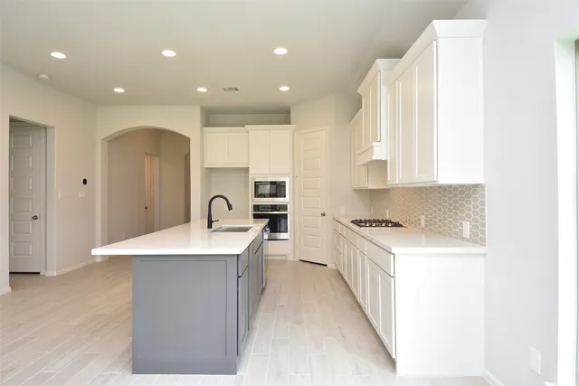 a open kitchen with kitchen island a sink stainless steel appliances and cabinets