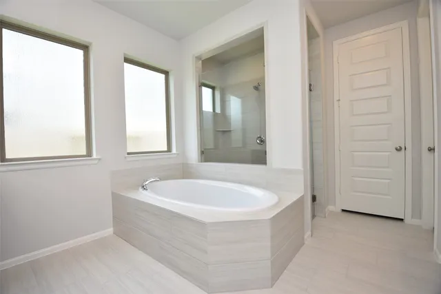 a bathroom with a tub a sink and a window