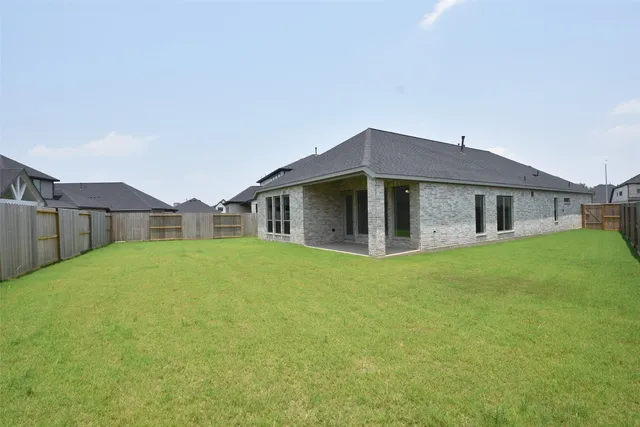 a view of a house with a yard and a fence