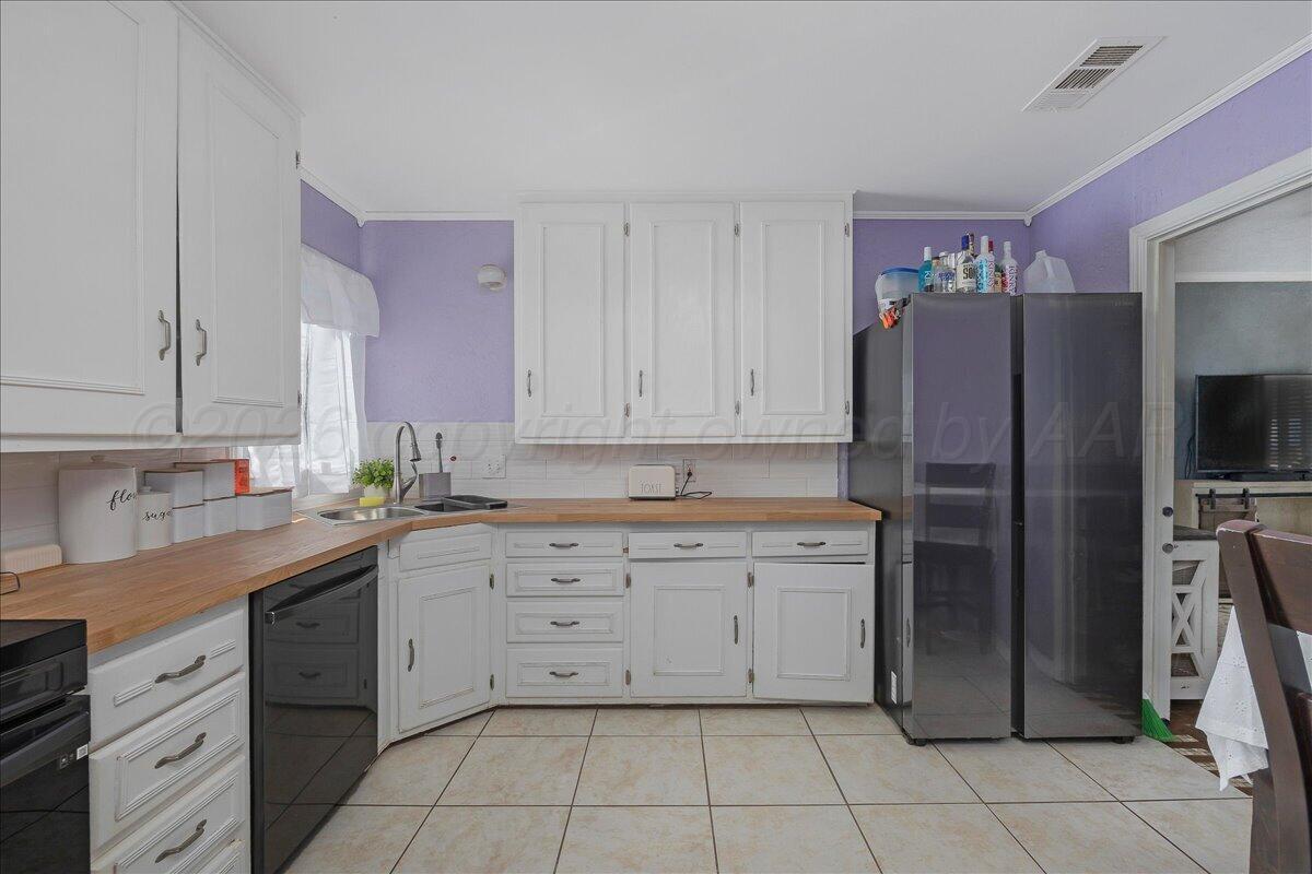 4011 Parker Street Amarillo, TX 79110 - Photo 7 of 17 a kitchen with a refrigerator sink and cabinets