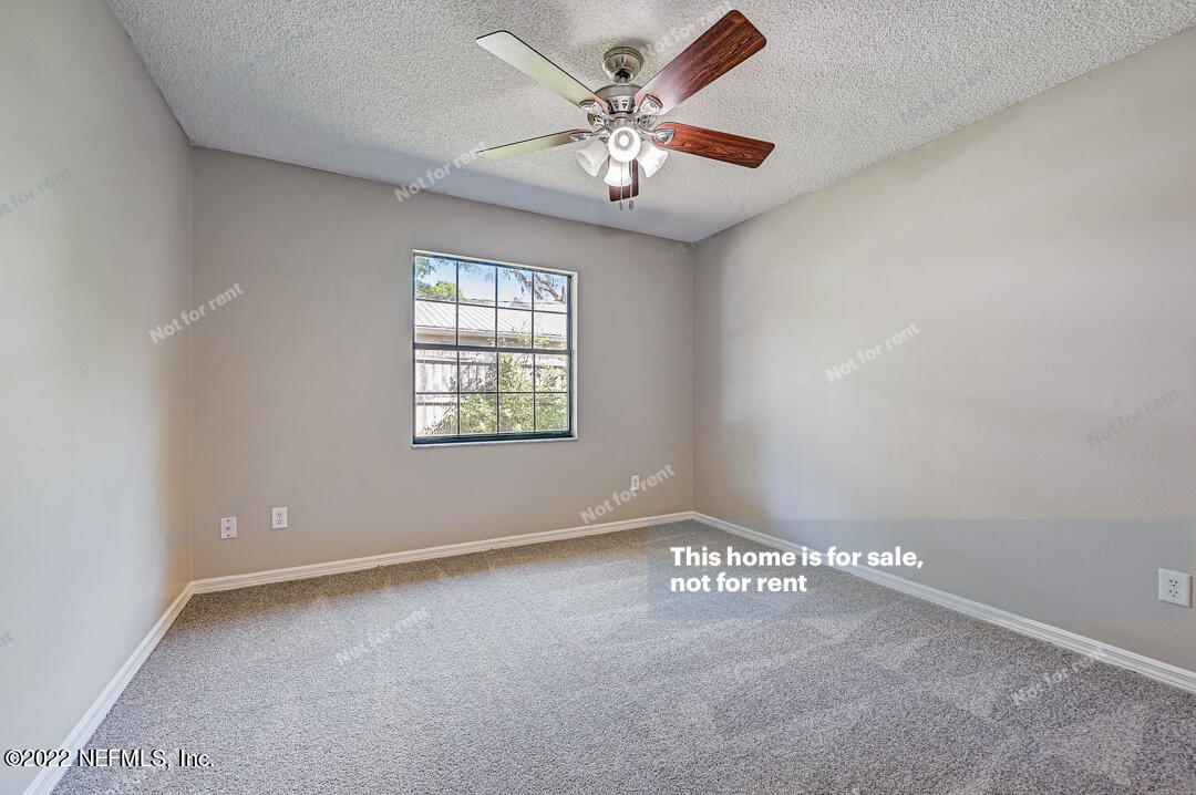 416 Shamrock Road St. Augustine, FL 32086 - Photo 13 of 29 an empty room with windows and chandelier fan