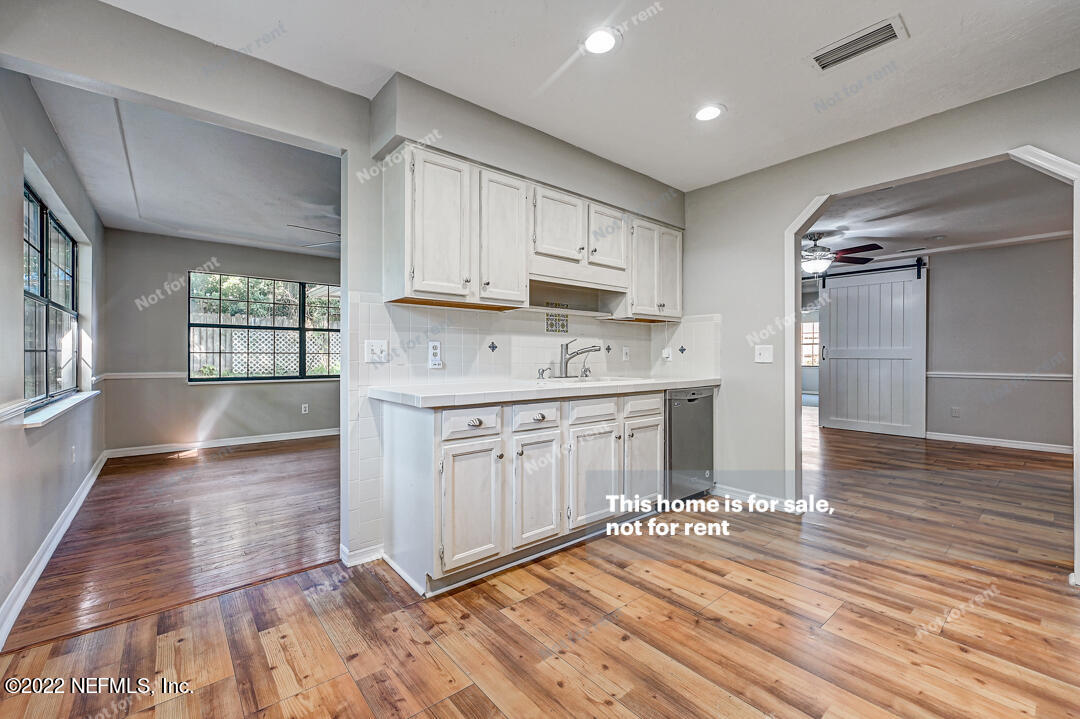 416 Shamrock Road St. Augustine, FL 32086 - Photo 19 of 29 a kitchen with stainless steel appliances granite countertop a refrigerator a sink dishwasher a stove and white countertops with wooden floor