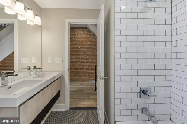 a bathroom with a double vanity sink mirror and shower