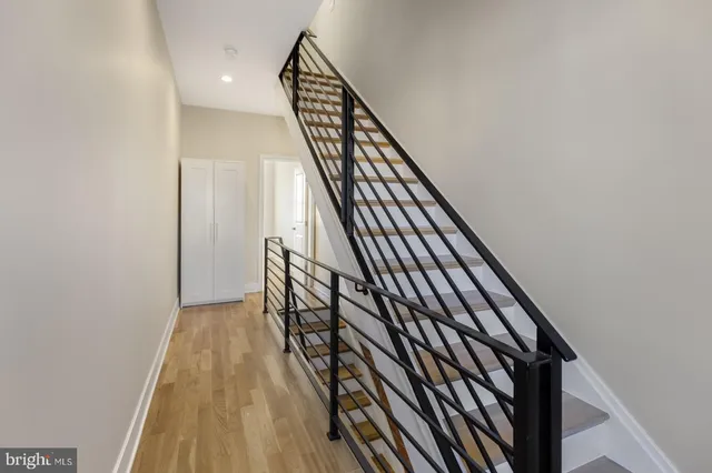 a view of stairs and hall with wooden floor