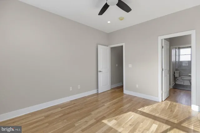 an empty room with fan and entrance