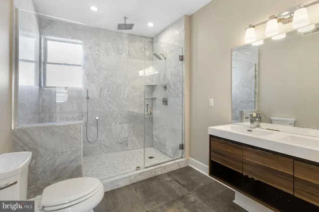 a bathroom with a double vanity sink toilet and shower