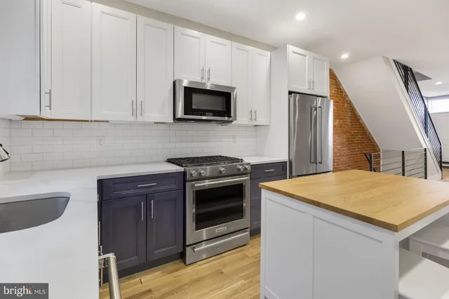 a kitchen with stainless steel appliances a stove microwave and sink