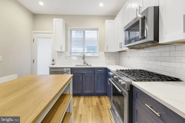 a kitchen with a stove a sink and a microwave