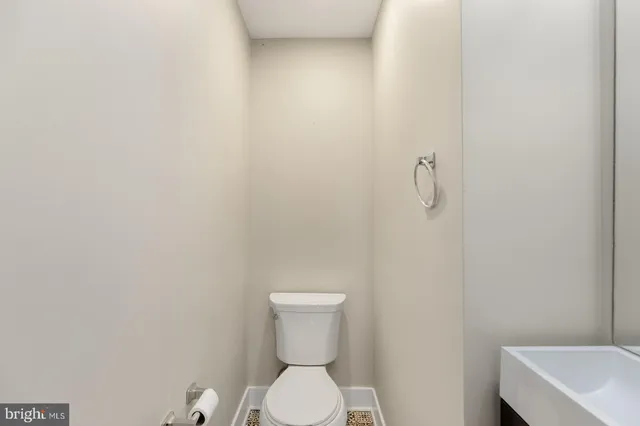 a white toilet sitting next to a white wall