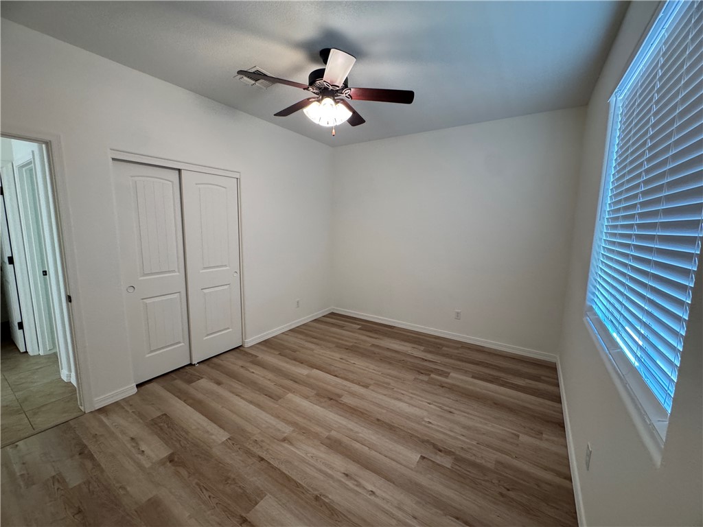 4263 East Medicine Bend Road Kingman, AZ 86401 - Photo 11 of 14 an empty room with wooden floor fan and window