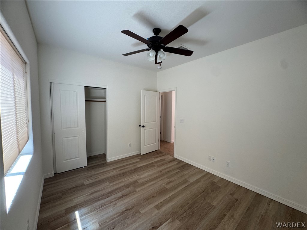 4263 East Medicine Bend Road Kingman, AZ 86401 - Photo 5 of 14 a view of empty room with wooden floor and fan