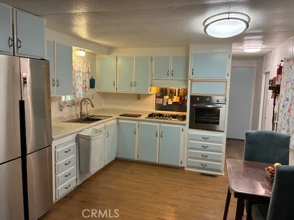 a kitchen with stainless steel appliances a stove refrigerator sink and cabinets
