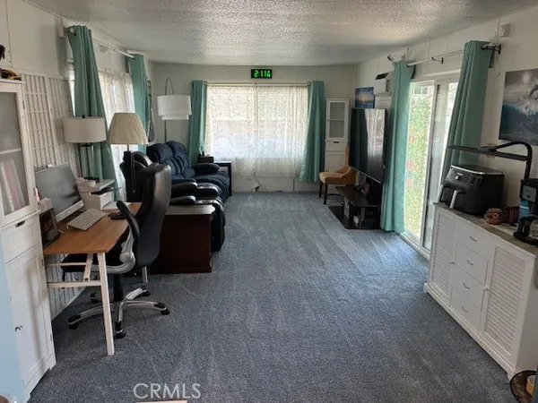 a view of a workspace with furniture and a window