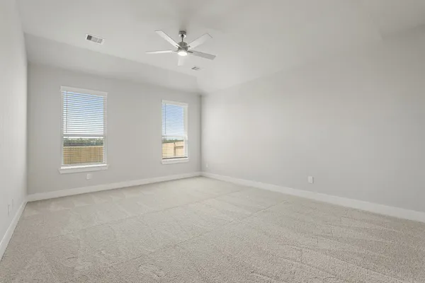 an empty room with windows and fan