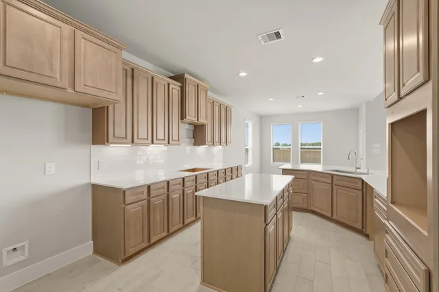 a large kitchen with cabinets and stainless steel appliances