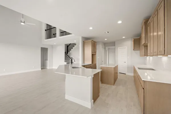 a view of kitchen with kitchen island stainless steel appliances sink refrigerator and microwave