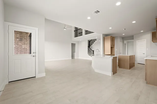 a view of a kitchen with kitchen island white cabinets and stainless steel appliances