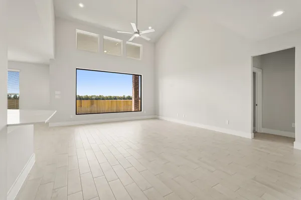 an empty room with windows and fan