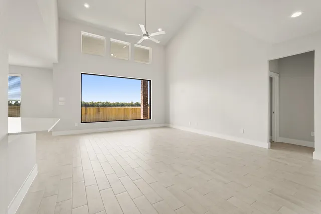an empty room with windows and fan