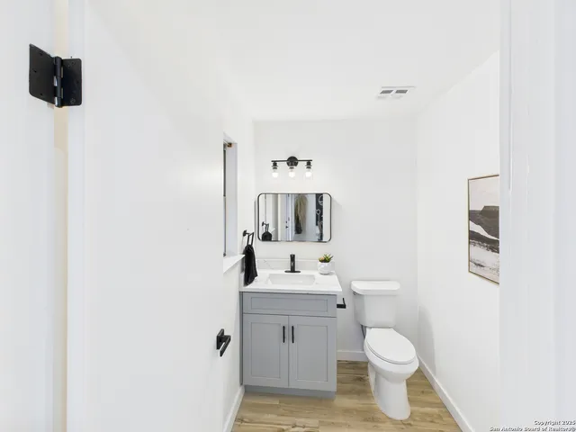 a bathroom with a sink toilet and mirror