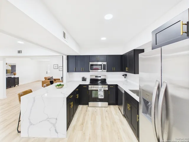 a large kitchen with stainless steel appliances lots of counter top space