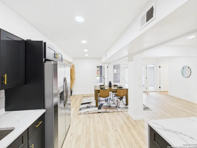 a kitchen with stainless steel appliances granite countertop a refrigerator and a stove top oven