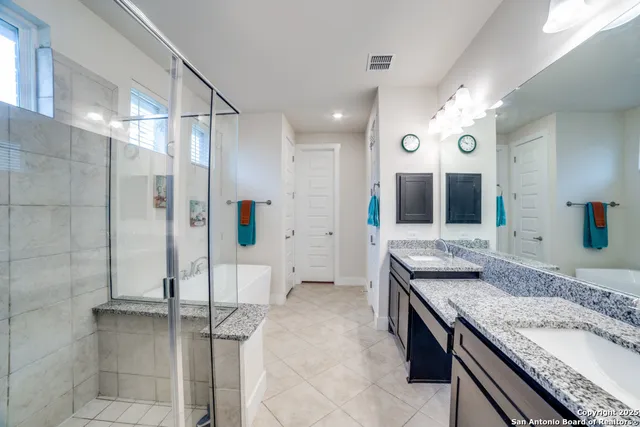 a spacious bathroom with a granite countertop sink mirror and shower