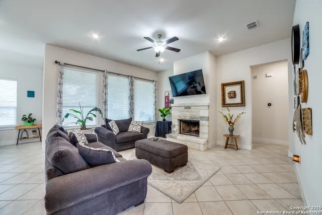 a living room with furniture a fireplace and a flat screen tv