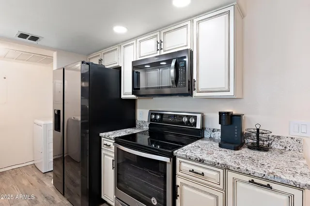 a kitchen with stainless steel appliances granite countertop a stove microwave and refrigerator