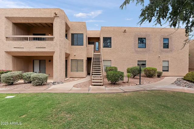 a view of a house with a yard and lawn chairs