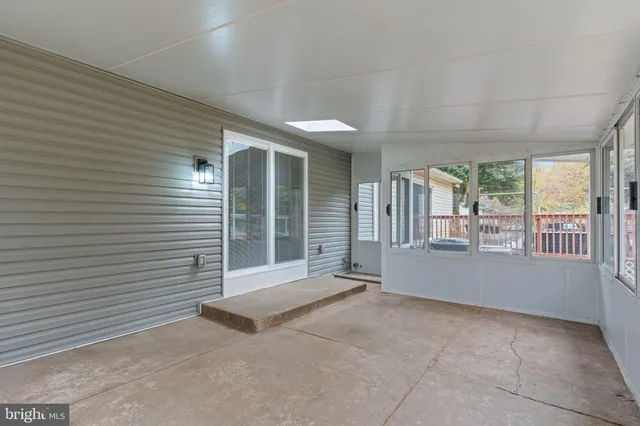 a view of an empty room with wooden floor and a fireplace