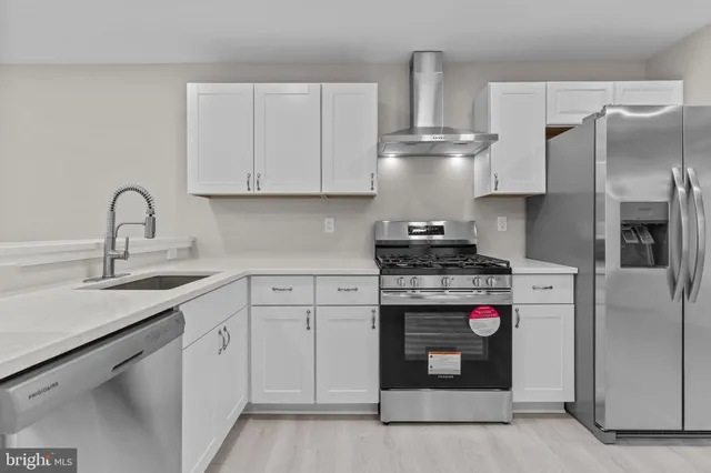 a kitchen with stainless steel appliances granite countertop a refrigerator sink and stove